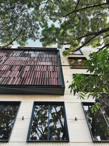 A detail of the mixed-use building's facade, highlighting the textured tile cladding that adds a layer of craftsmanship and visual interest.