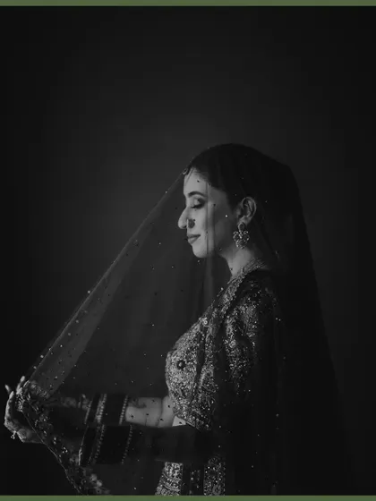 A classic black and white bridal portrait, with the veil creating a soft, ethereal glow around her. This timeless shot captures her grace and the quiet emotion of the moment.