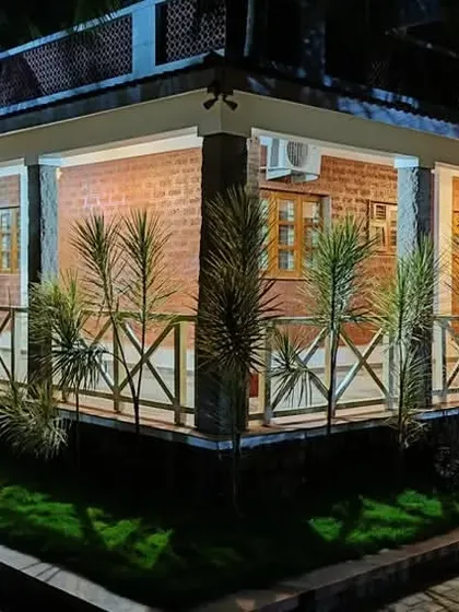 The farmhouse at night. The lighting design highlights the texture of the brick walls and the rhythm of the columns along the veranda, creating a warm and secure feeling within the vast grove.