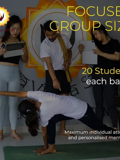 To ensure you receive true mentorship, I keep my teacher training groups small, with a maximum of 20 students per batch. This image shows a teacher providing personalized alignment correction, which is a core part of my programs. This focused attention is how you build the confidence to teach others.