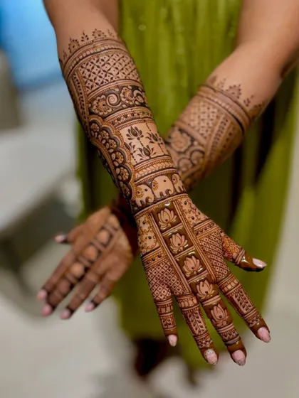 A wedding mehendi with blocks of lotus and elephant motifs, creating a unique, structured look.