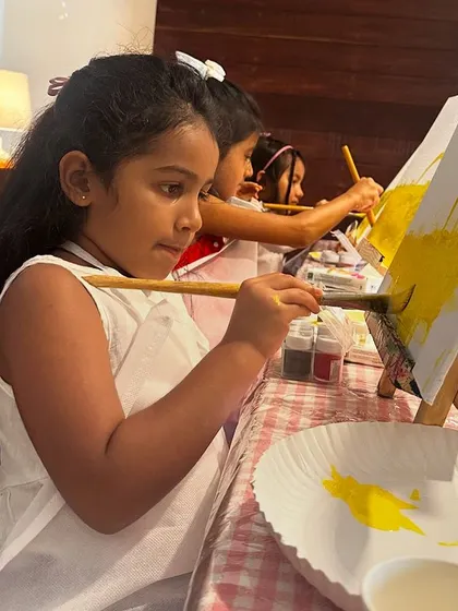 A young artist concentrating on her rainbow painting. It's amazing to watch kids get lost in the creative process.
