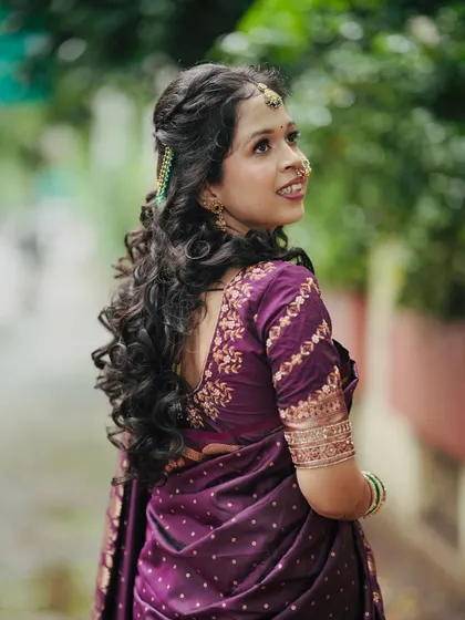 A beautiful back profile showcasing a half-up, half-down hairstyle with voluminous curls. This romantic hairstyle is perfect for an engagement ceremony.