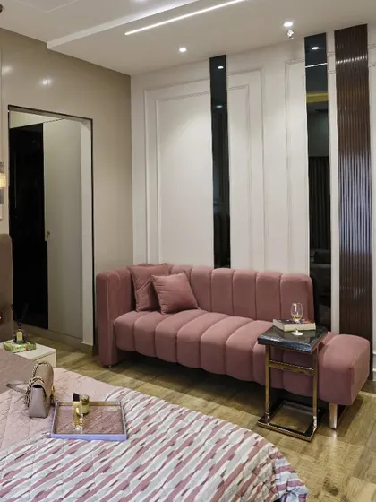 This pink channel-tufted daybed is the perfect spot for reading or relaxing. The mirrored and fluted panels on the wall add depth and a touch of art deco style.
