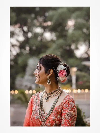 A side profile of the bride, showing off her beautiful floral hair accessory and jewelry.