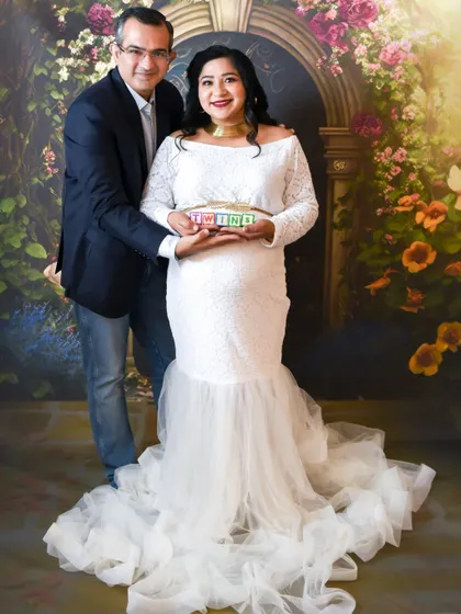 A joyful couple portrait announcing they are expecting twins, holding up letter blocks in our studio.