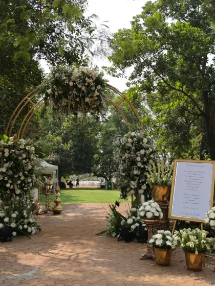 The grand welcome entrance for a wedding, with a lush floral arch and a personalized welcome sign for the couple.