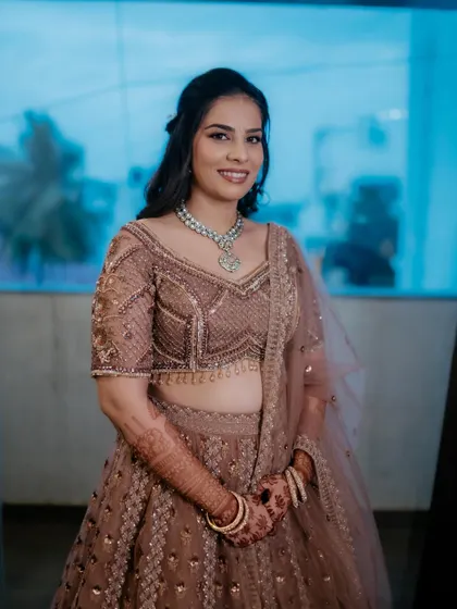 A full view of the bride in her beautiful mauve-toned lehenga. The makeup is soft and romantic, perfectly matching the color palette of her outfit.