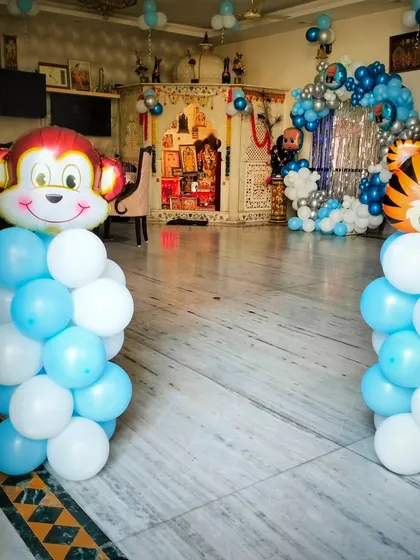 Fun animal-themed balloon pillars for a kids' party. These pillars are topped with large monkey and tiger head foil balloons, adding a playful and wild touch to the entrance or party space.