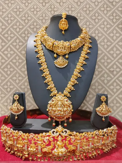 A complete Lakshmi-themed bridal set in a rich antique gold finish, including choker, haram, and vaddanam.