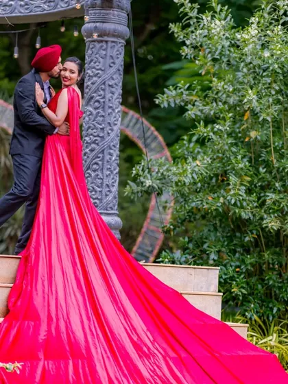 An intimate and romantic pose on the steps. The cascading red gown adds a touch of drama and elegance to this beautiful moment between the couple.