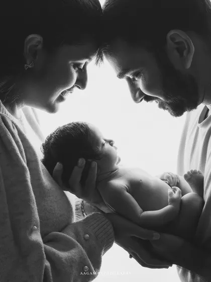 The black and white version of a dreamy high-key portrait. Removing the color puts all the focus on the loving gazes between the new parents and their baby.