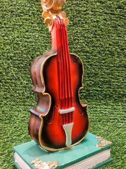 Save in style with this violin-shaped piggy bank that rests on a book. It's a beautiful showpiece that doubles as a money box, perfect for music lovers.