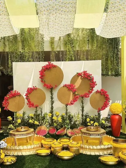 A beautiful setup for a Haldi ceremony, with brass urlis and bowls filled with turmeric and flowers. The backdrop of yellow drapes and unique floral arrangements creates a traditional yet stylish look.