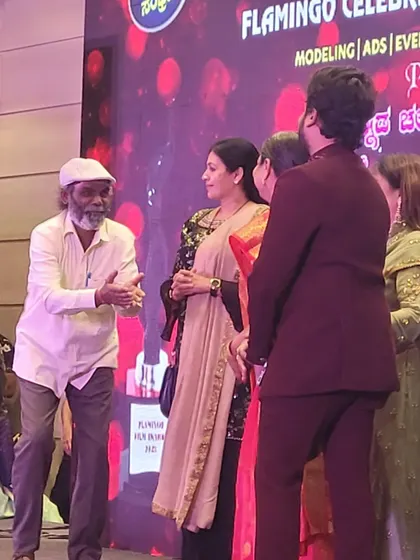 Veteran actor Vaijanath Biradar interacting with other guests on stage during the Sandalwood Stars Night. We manage stage flow for all guests and performers.
