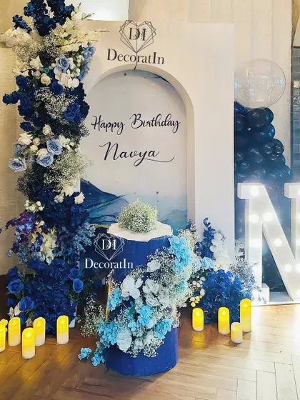 The full view of the 15th birthday backdrop, with the marquee 'N' and the beautiful cascade of blue and white flowers.