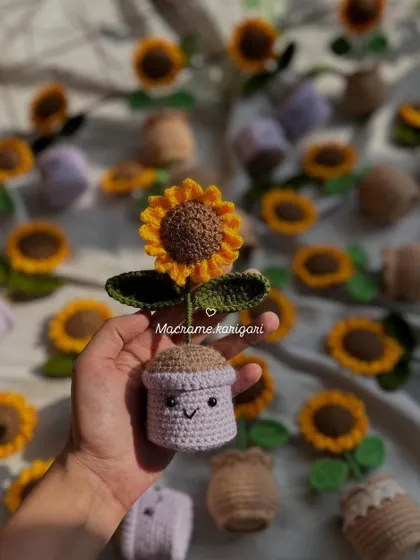A single mini crochet sunflower pot with a cute smiling face. These little pots are designed to brighten up your desk or any small corner of your home.