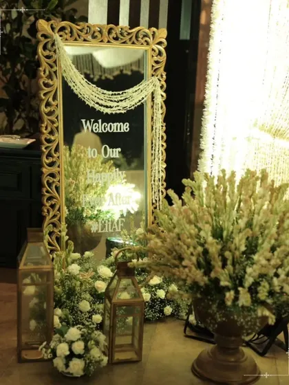 An ornate, gold-framed mirror welcoming guests to a 'Happily Ever After'. The entrance sets the tone for the entire evening, and we craft these first impressions with elegance and a touch of romance.