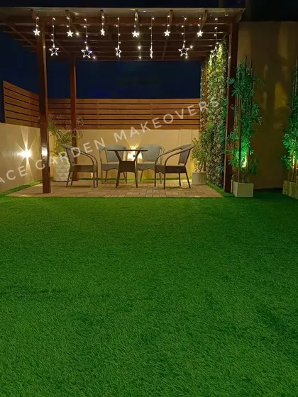 A wider view of our pergola dining area project. The combination of the wooden structure, privacy screening, artificial grass, and ambient lighting creates a complete and inviting outdoor room.