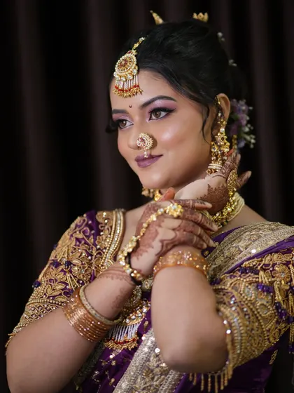 A side profile showcasing the intricate details of the bridal hairstyle and jewelry. The hair is pulled back into an elegant bun adorned with flowers, a classic choice for a Marathi bride.