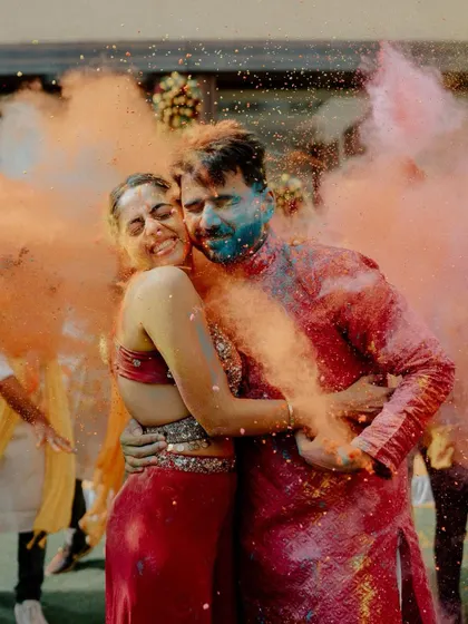 A vibrant explosion of color and love. This shot of Sarthak and Hayati embracing amidst clouds of colored powder is the epitome of a fun, modern Haldi celebration.
