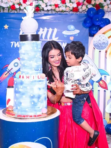 A mother and son share a sweet moment by the incredible space-themed birthday cake.