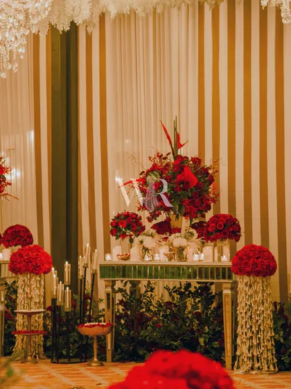 Another view of the red floral console, showing how we use different flowers like roses and coxcombs to create texture and visual interest. The pillars are wrapped in strings of mogra for a traditional touch.