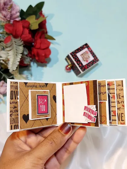 An open view of a tiny accordion-style scrapbook. It unfolds to reveal a sequence of small photos and decorative elements.