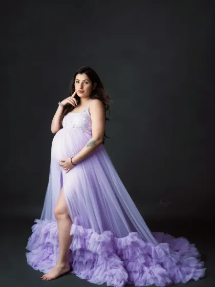 A confident and modern pose. The side slit in this lavender gown adds a touch of contemporary style to this stunning solo maternity portrait.