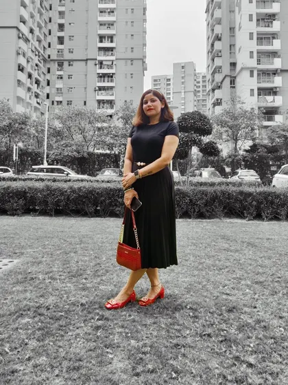 A similar shot of the all-black outfit with red accessories, showing a full-length view of the classic, elegant style.