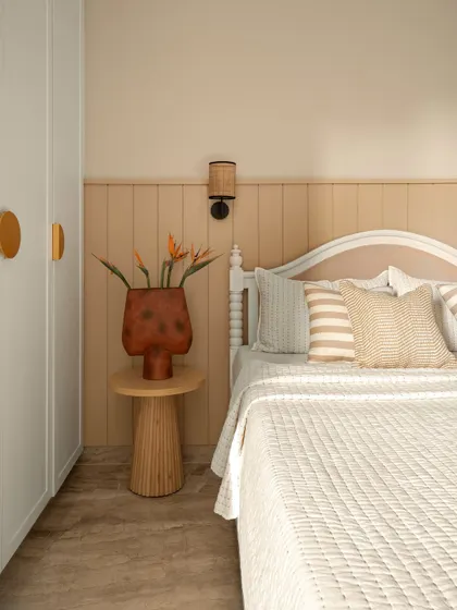 This guest bedroom is a warm, neutral retreat. The bed features a simple, classic headboard, and the wall behind it has wainscoting in a soft beige tone, creating a calm and simple space.