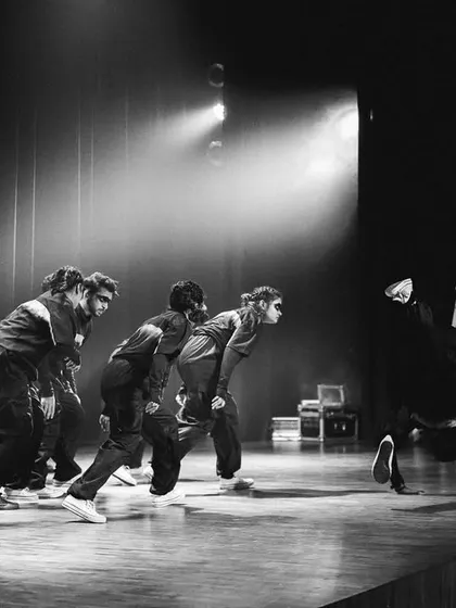 A black and white shot capturing the raw energy of a performance, with motion blur emphasizing the speed and grace of the dancers.