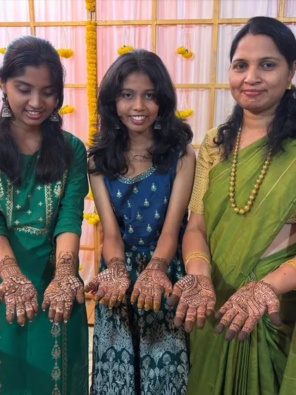 Three generations of beautiful ladies from the same family, all happy with their intricate mehendi designs.