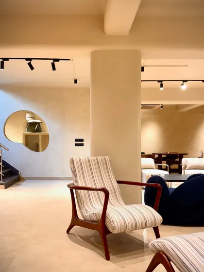 This striped armchair showcases a more traditional mid-century modern silhouette, with a gracefully curved wooden frame that adds a touch of calmness and elegance to the space.