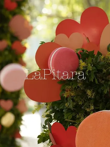Decorative floral pillars adorned with red and pink hearts and macarons, adding a sweet touch to the entrance.