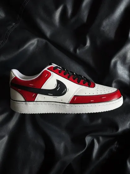 A side profile of the red cartoon custom sneaker on a black background.