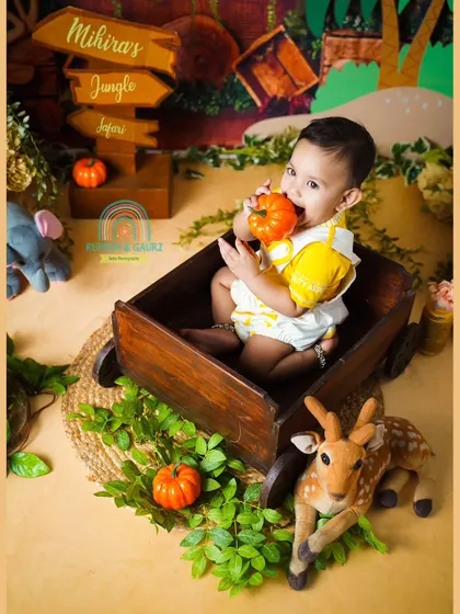 A cute moment from a jungle safari themed shoot, where the birthday girl decided the pumpkin prop looked delicious.