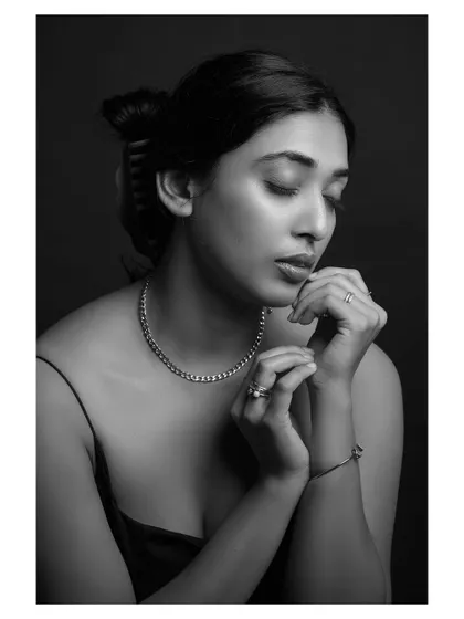 A quiet and thoughtful black and white portrait. The model's pose and expression convey a sense of introspection and peace.
