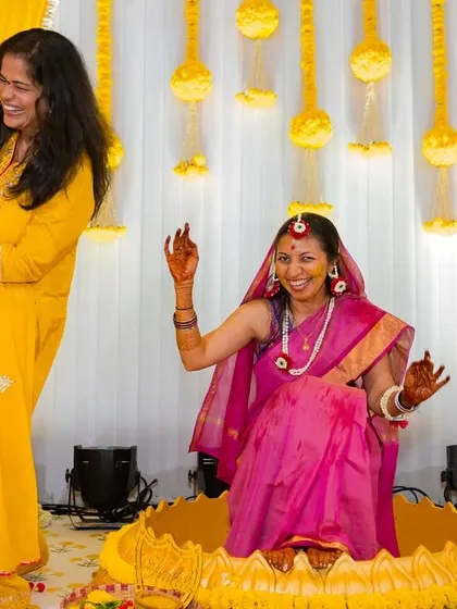 The bride and her sister share a dance and a laugh during the haldi festivities, a perfect candid moment.