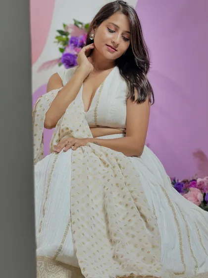 Another angle of the white lehenga set. The fabric has subtle gold detailing that adds a touch of shimmer and sophistication.