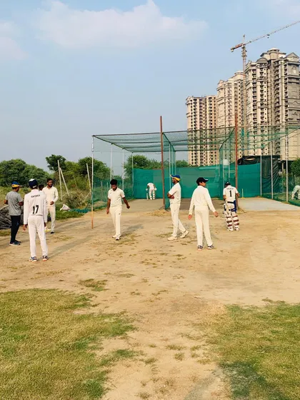 Players gather around the net area for a practice session. This is the hub of activity for teams before they take the main field for their match.