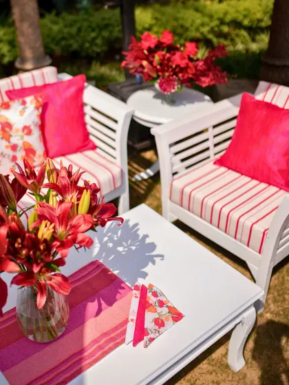 A seating area with striped cushions and bright pink accents, creating a cheerful and inviting space.
