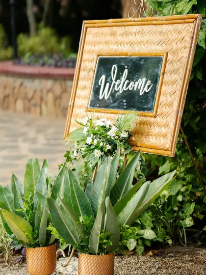 Another view of the sustainable and stylish welcome sign, surrounded by lush greenery.