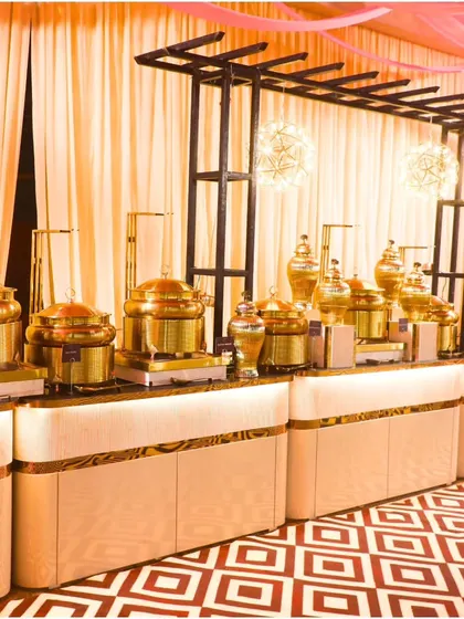An elegant buffet line with a geometric-patterned floor and pink and cream drapery. We work to integrate our setup seamlessly into your event's overall design and color scheme.