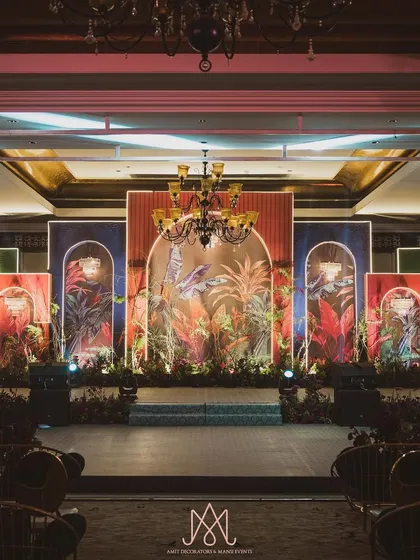 The full stage view of the contemporary sangeet, where multiple printed panels create a rich, artistic, and colorful backdrop for the evening's performances.