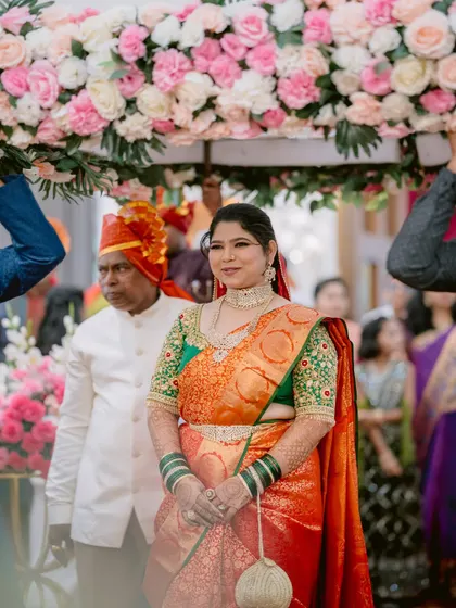 The bride, Prerna, making her grand entrance under a floral canopy, a picture of grace.