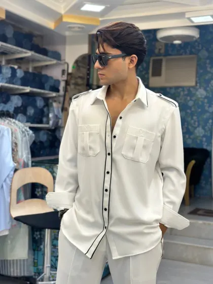 A full look at the white co-ord set with black piping. The relaxed fit and sharp detailing make it a versatile outfit for various occasions, from a brunch to a casual evening out.
