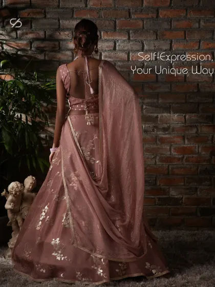 The back of this dusty rose lehenga showcases a beautiful drape and delicate tassels, allowing for self-expression in a unique and elegant way.
