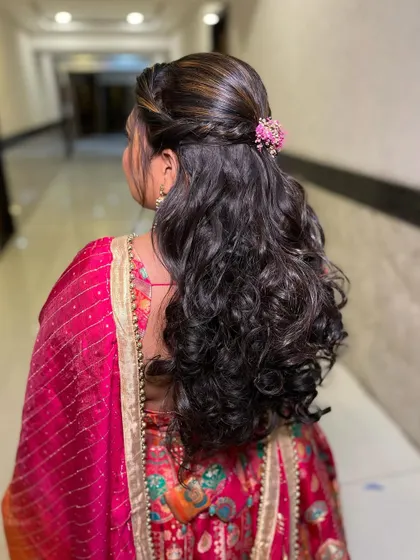 A view of the beautiful half-up, half-down hairstyle with soft curls, perfect for a pre-wedding event.