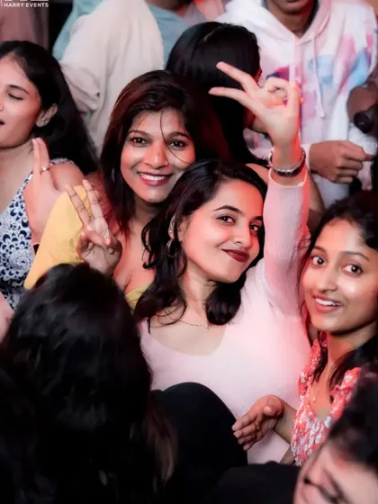 Guests smiling and making peace signs, fully immersed in the party vibe. It's all about good times and positive energy.